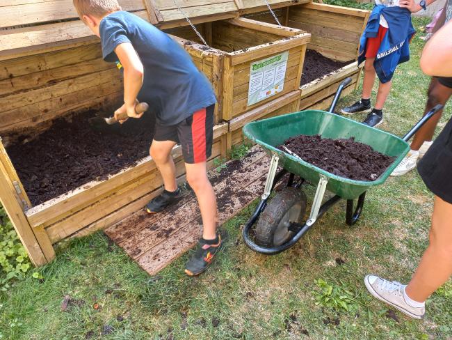 Collégiens qui transvasent le contenu du bac d'apports vers le bac de maturation.